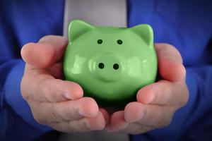 A green piggy bank held in a pair of hands